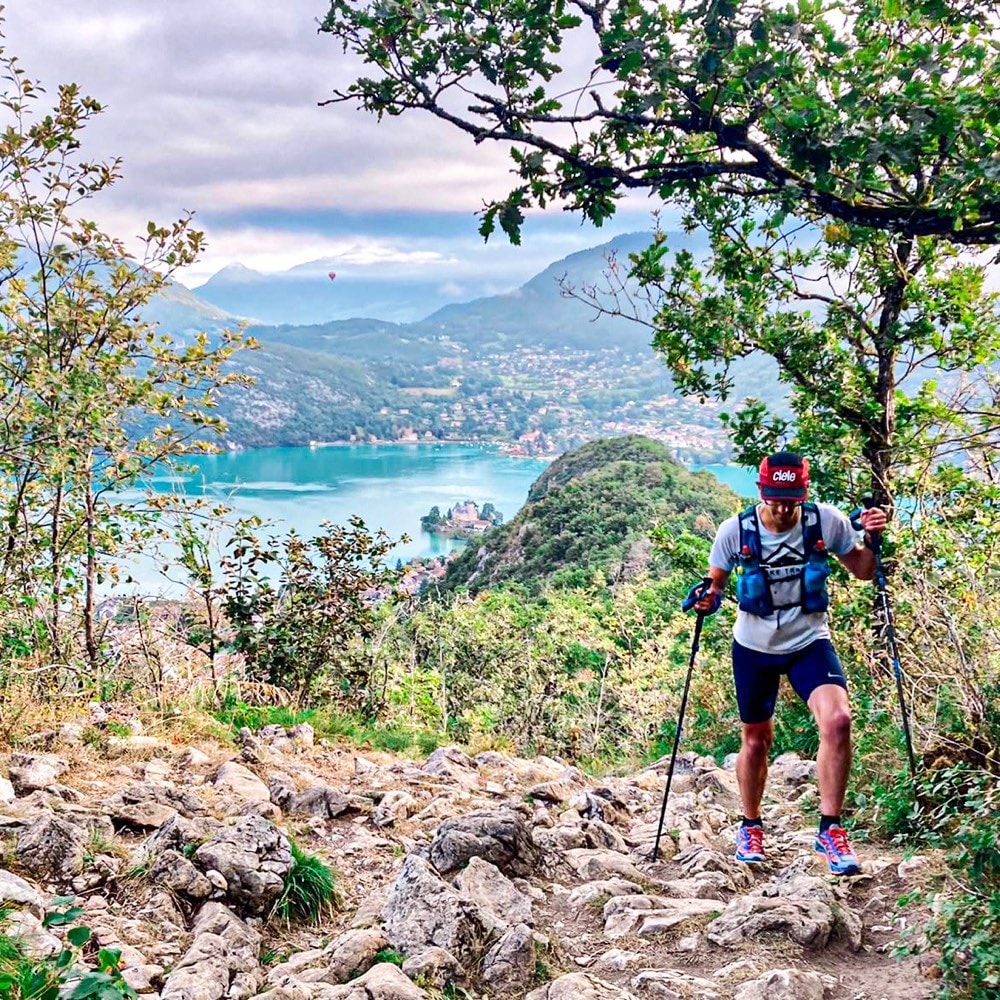 Francesco climbing a rocky trail above a lake